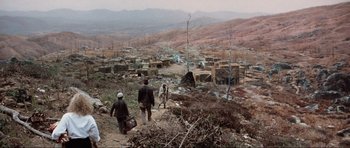 Movie still from “Indiana Jones and the Temple of Doom” (1984), directed by Steven Spielberg – Two men walking down a dirt path in a mountainous area; Extreme Wide shot, High angle