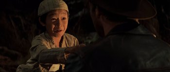 Movie still from “Indiana Jones and the Temple of Doom” (1984), directed by Steven Spielberg – Two people are talking in the dark outside; Close Up shot, Over the shoulder angle