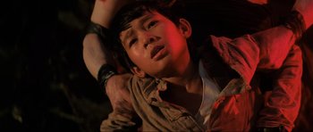 Movie still from “Indiana Jones and the Temple of Doom” (1984), directed by Steven Spielberg – A young boy with his arm around a man's shoulder; Close Up shot, Overhead angle