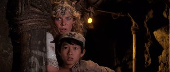 Movie still from “Indiana Jones and the Temple of Doom” (1984), directed by Steven Spielberg – A woman and a young boy are posing for a picture; Close Up shot, Low angle