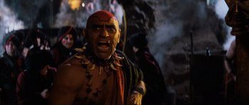 Movie still from “Indiana Jones and the Temple of Doom” (1984), directed by Steven Spielberg – A man with a red and black head dress is screaming; Close Up shot, Low angle