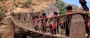 Movie still from “Indiana Jones and the Temple of Doom” (1984), directed by Steven Spielberg – A group of people walking across a rope bridge; Wide shot, Low angle
