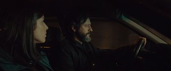 Movie still from “Infiesto” (2023), directed by Patxi Amezcua – A man sitting in the driver's seat of a car at night; Close Up shot, Over the shoulder angle