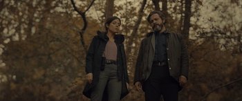 Movie still from “Infiesto” (2023), directed by Patxi Amezcua – A man and a woman standing next to each other in the woods; Medium shot, Low angle