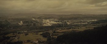 Movie still from “Infiesto” (2023), directed by Patxi Amezcua – An aerial view of an industrial area in the middle of a valley; Extreme Wide shot, High angle