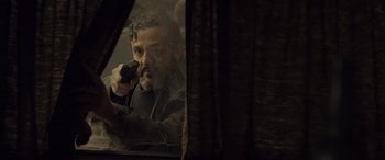 Movie still from “Infiesto” (2023), directed by Patxi Amezcua – A man holding a gun while sitting in a car; Close Up shot, Over the shoulder angle