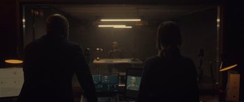 Movie still from “Infiesto” (2023), directed by Patxi Amezcua – Two people are sitting in front of a television; Medium shot, Over the shoulder angle