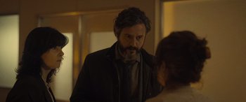 Movie still from “Infiesto” (2023), directed by Patxi Amezcua – A man standing next to a woman in a room; Close Up shot, Over the shoulder angle