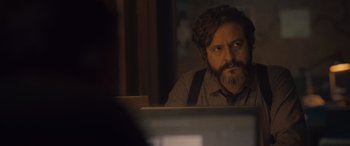 Movie still from “Infiesto” (2023), directed by Patxi Amezcua – A man sitting at a desk in front of a computer monitor; Close Up shot, Over the shoulder angle