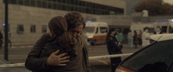 Movie still from “Infiesto” (2023), directed by Patxi Amezcua – A man and a woman hug in front of an ambulance; Close Up shot, Over the shoulder angle