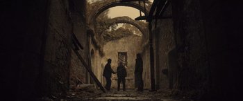 Movie still from “Infiesto” (2023), directed by Patxi Amezcua – A group of people standing in an abandoned building; Wide shot, Low angle