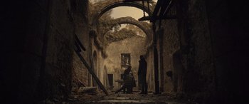 Movie still from “Infiesto” (2023), directed by Patxi Amezcua – Two men standing in an abandoned building with a hammer; Extreme Wide shot, Low angle