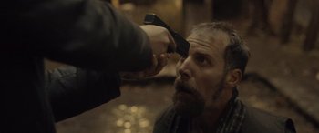 Movie still from “Infiesto” (2023), directed by Patxi Amezcua – A man getting his hair cut by a barber; Close Up shot, Over the shoulder angle