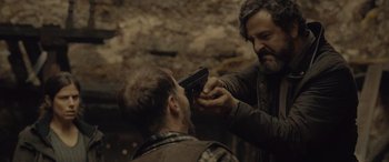 Movie still from “Infiesto” (2023), directed by Patxi Amezcua – A man is holding a gun up to another man's head; Close Up shot, Over the shoulder angle