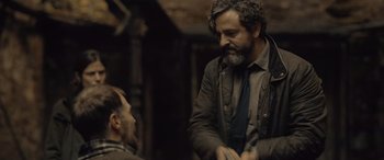 Movie still from “Infiesto” (2023), directed by Patxi Amezcua – A man with a beard is talking to another man; Medium shot, Over the shoulder angle