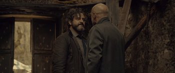 Movie still from “Infiesto” (2023), directed by Patxi Amezcua – Two men standing next to each other in a room; Medium shot, Over the shoulder angle