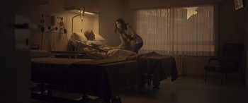 Movie still from “Infiesto” (2023), directed by Patxi Amezcua – A man and a woman in a hospital room; Wide shot, Low angle