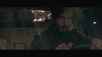 Movie still from “Infinite” (2021), directed by Antoine Fuqua – A man sitting in the driver's seat of a car; Close Up shot, Over the shoulder angle