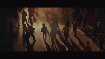 Movie still from “Infinite” (2021), directed by Antoine Fuqua – A group of people walking on a sidewalk; Extreme Wide shot, High angle