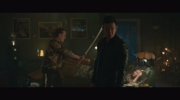 Movie still from “Infinite” (2021), directed by Antoine Fuqua – A man holding a baseball bat while standing next to another man; Wide shot, Over the shoulder angle