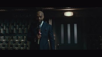 Movie still from “Infinite” (2021), directed by Antoine Fuqua – A man in a suit and tie holding an umbrella; Medium shot, Over the shoulder angle