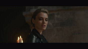 Movie still from “Infinite” (2021), directed by Antoine Fuqua – A woman in a black leather jacket holding a candle; Close Up shot, Over the shoulder angle