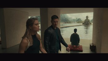 Movie still from “Infinite” (2021), directed by Antoine Fuqua – A man and a woman standing next to each other in front of a body of water; Wide shot, High angle