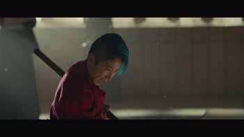 Movie still from “Infinite” (2021), directed by Antoine Fuqua – A woman with blue hair is smiling for the camera; Close Up shot, Low angle