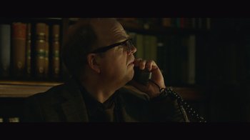 Movie still from “Infinite” (2021), directed by Antoine Fuqua – A man with glasses talking on a phone; Close Up shot, Low angle
