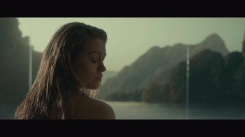 Movie still from “Infinite” (2021), directed by Antoine Fuqua – A beautiful young woman with her eyes closed near a body of water; Medium shot, Low angle