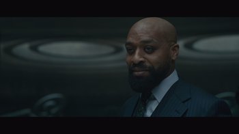 Movie still from “Infinite” (2021), directed by Antoine Fuqua – A man in a suit and tie with a goatee; Close Up shot, Low angle