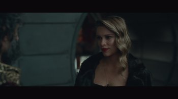 Movie still from “Infinite” (2021), directed by Antoine Fuqua – A beautiful blonde woman wearing a black dress; Close Up shot, Low angle