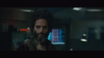 Movie still from “Infinite” (2021), directed by Antoine Fuqua – A man with a beard is standing in front of a monitor; Close Up shot, Over the shoulder angle