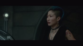 Movie still from “Infinite” (2021), directed by Antoine Fuqua – A woman with a shaved head wearing a black jacket; Close Up shot, Over the shoulder angle