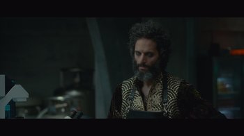 Movie still from “Infinite” (2021), directed by Antoine Fuqua – A man with a beard is standing in front of a microphone; Medium shot, Over the shoulder angle