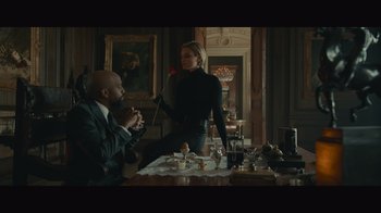 Movie still from “Infinite” (2021), directed by Antoine Fuqua – A man and a woman sitting at a dining room table; Wide shot, Over the shoulder angle