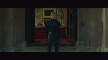 Movie still from “Infinite” (2021), directed by Antoine Fuqua – A woman standing in front of a building wearing a black outfit; Medium shot, Low angle