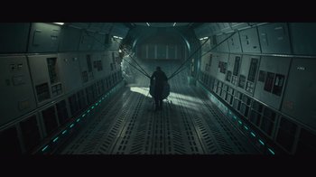 Movie still from “Infinite” (2021), directed by Antoine Fuqua – A man walking down a hallway in a building; Extreme Wide shot, Overhead angle