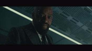 Movie still from “Infinite” (2021), directed by Antoine Fuqua – A man in a suit and tie in a dark room; Close Up shot, Low angle