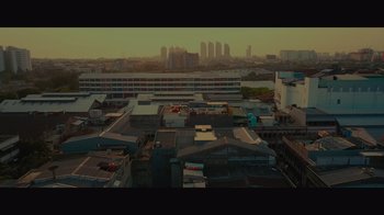 Movie still from “Infinite” (2021), directed by Antoine Fuqua – An aerial view of a city with buildings in the background; Extreme Wide shot, Low angle