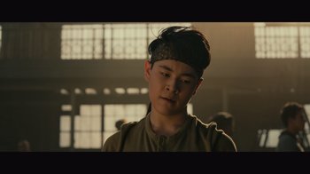 Movie still from “Infinite” (2021), directed by Antoine Fuqua – A young man with a bandage on his head is looking down; Close Up shot, Low angle