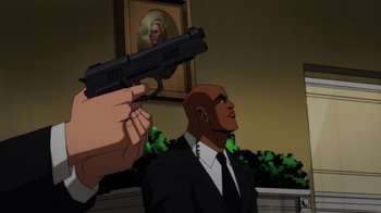 Movie still from “Injustice” (2021), directed by Matt Peters – A man in a suit and tie holding a gun up to his face; Medium shot, Low angle