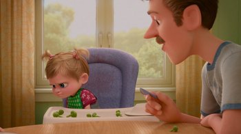 Movie still from “Inside Out” (2015), directed by Pete Docter – A man and a girl eating peas on a table; Medium shot, Over the shoulder angle