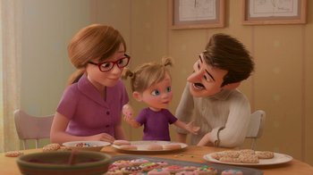 Movie still from “Inside Out” (2015), directed by Pete Docter – A family sitting at a table with a plate of cookies; Medium shot, Over the shoulder angle