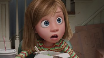 Movie still from “Inside Out” (2015), directed by Pete Docter – A girl with brown hair is holding a box of food; Close Up shot, High angle