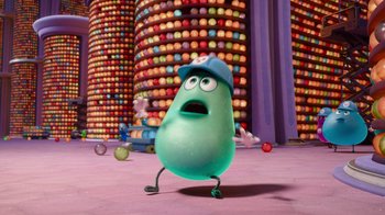Movie still from “Inside Out” (2015), directed by Pete Docter – A character in a hat is standing in front of a wall of apples; Wide shot, Low angle