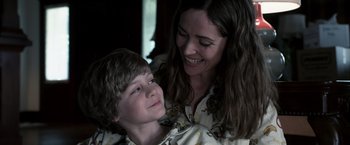 Movie still from “Insidious” (2010), directed by James Wan – A woman and a boy smiling for the camera; Close Up shot, Over the shoulder angle
