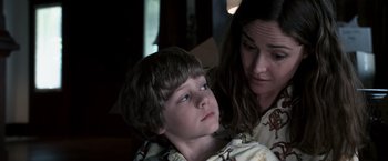 Movie still from “Insidious” (2010), directed by James Wan – A woman and a boy are looking at the camera; Close Up shot, Over the shoulder angle