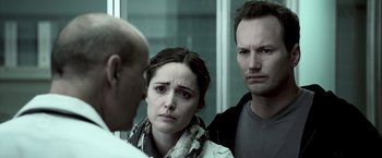 Movie still from “Insidious” (2010), directed by James Wan – Two men and a woman are looking at each other in the mirror; Close Up shot, Over the shoulder angle