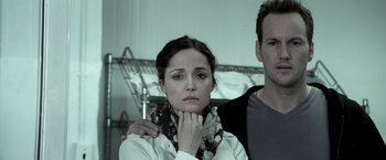 Movie still from “Insidious” (2010), directed by James Wan – A man and a woman standing next to each other; Close Up shot, Low angle